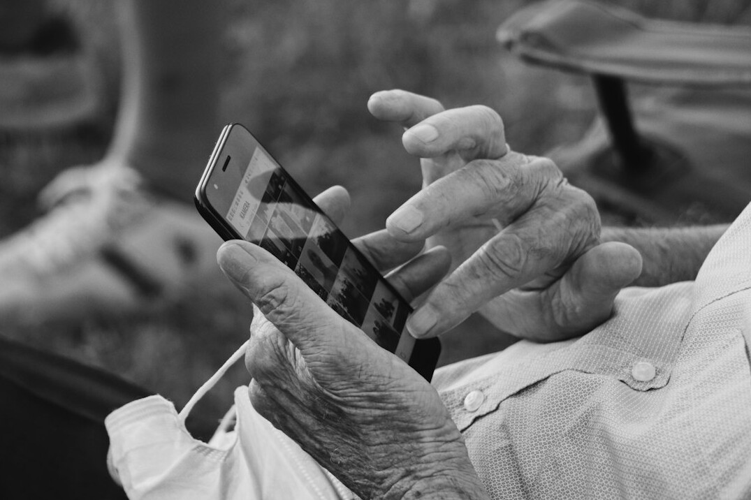 Hands holding a smartphone reading news
